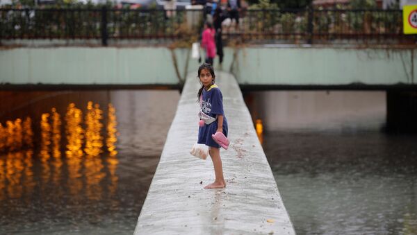 فتاة حافية القدمين تقف وسط شارع عائم نتيجة الفيضانات التي اجتاحت اسطنبول، تركيا، 17 أغسطس/آب 2019 - سبوتنيك عربي