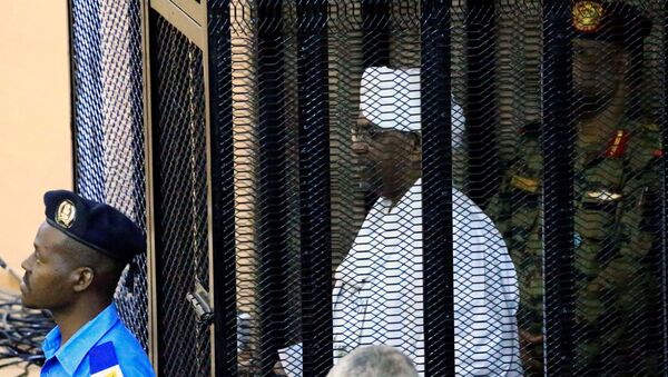 الرئيس السوداني المعزول عمر البشير داخل قفص المحاكمة - سبوتنيك عربي