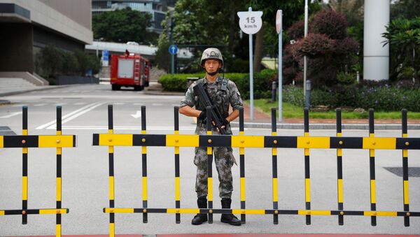 جندي صيني من جيش التحرير الشعبي يحرس مدخل مقر حامية جيش التحرير في هونغ كونغ في المنطقة التجارية المركزية في هونغ كونغ - سبوتنيك عربي