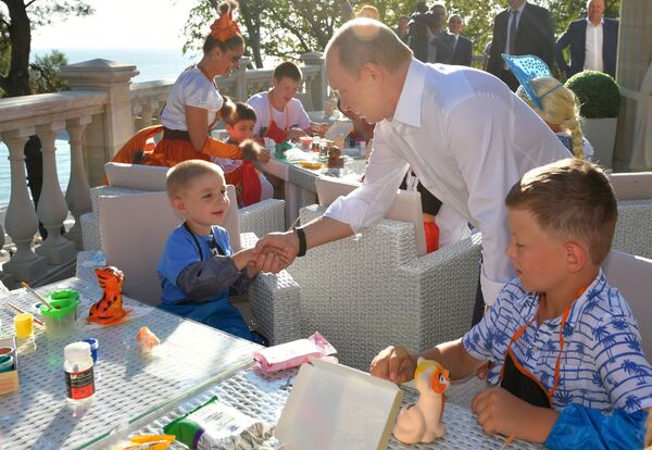 الرئيس الروسي فلاديمير بوتين خلال اجتماع مع أطفال الأسر المتضررة من الفيضانات في منطقة إركوتسك في سوتشي - سبوتنيك عربي