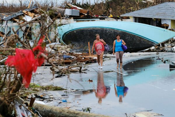 نساء يسرن عبر الأنقاض بعد إعصار دوريان في جزيرة كريت أباكو في مارش هاربر، جزر البهاما 3 سبتمبر 2019 - سبوتنيك عربي
