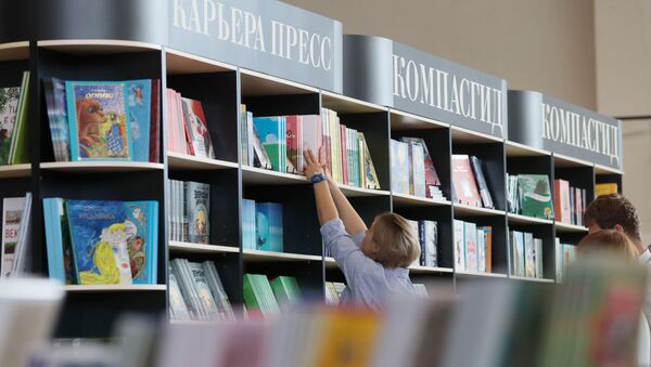 أحد الزائرين ينظر إلى الكتب في أحد المدرجات في معرض موسكو الدولي 32 للكتاب في موسكو - سبوتنيك عربي