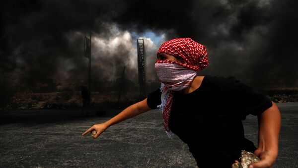 أحد المتظاهرين الفلسطينيين يقذف الحجارة بالقرب من مستوطنة يهودية في بيت إيل، الأراضي المحتلة بالضفة الغربية، 9 سبتمبر 2019 - سبوتنيك عربي