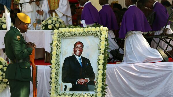 جنود يقفون بجانب صورة لرئيس زيمبابوي السابق روبرت موغابي قبل دفن جثمانه في قريته الريفية في كوتاما، 28 سبتمبر/أيلول 2019 - سبوتنيك عربي