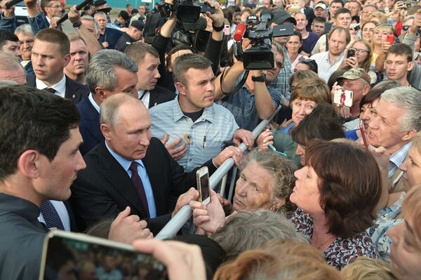 الرئيس الروسي فلاديمير بوتين يتحدث مع السكان المحليين بعد زيارة مدرسة الثانوية رقم 6 في مدينة تولون، إقليم سيبيريا - سبوتنيك عربي