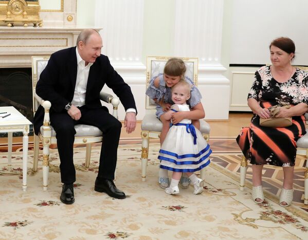 الرئيس الروسي فلاديمير بوتين خلال لقائه مع عائلات تضررت من فيضانات هائلة في منطقة إركوتسك الروسية في الكرملين، موسكو 25 يوليو/ تموز 2019 - سبوتنيك عربي