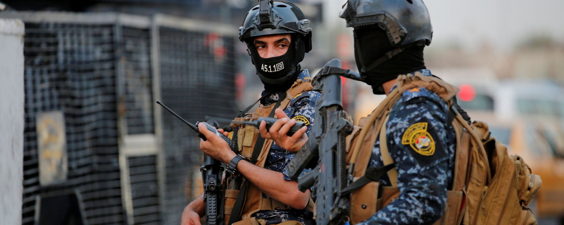 أفراد من الشرطة الفيدرالية العراقية يراقبون مركبات عسكرية في أحد شوارع بغداد، 7 أكتوبر/تشرين الأول 2019 - سبوتنيك عربي, 1920, 22.02.2021
