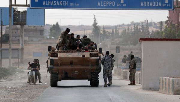 مقاتلون سوريون مدعومون من تركيا يجلسون على شاحنة عسكرية في بلدة تل أبيض الحدودية - سبوتنيك عربي