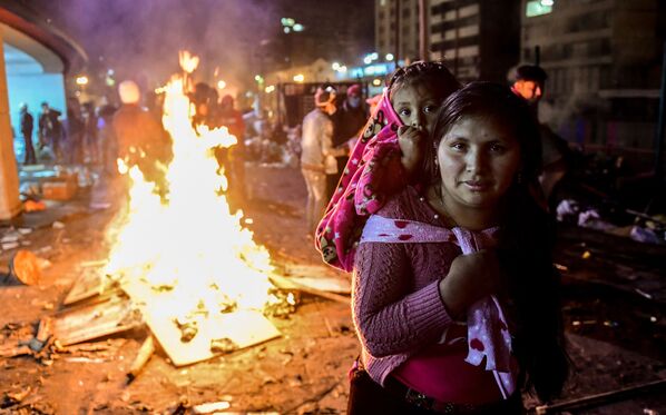 امرأة وابنتها أثناء الاحتجاجات بالقرب من قصر الثقافة في كيتو، الإكوادور 13 أكتوبر 2019 - سبوتنيك عربي