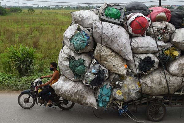 يقوم جامع النفايات بنقل الخردة البلاستيكية لإعادة التدوير في ضواحي هانوي، فيتنام 15 أكتوبر 2019 - سبوتنيك عربي