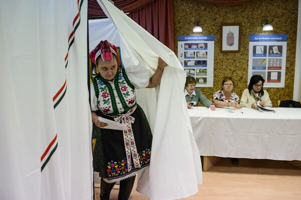 امرأة ترتدي الزي التقليدي الوطني، تغادر مركز الاقتراع حيث تقام انتخابات محلية في قرية ريموك في المجر، 13 أكتوبر 2019 - سبوتنيك عربي