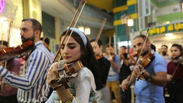 موسيقيات وعازفون في أوركسترا مضيئة في العراق - سبوتنيك عربي