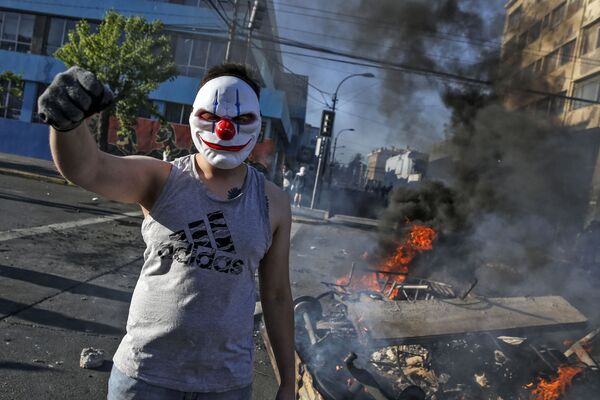متظاهر ملثم أثناء تجدد الاحتجاجات في سانتياغو بعد مقتل اثنين من المتظاهرين، تشيلي 20 أكتوبر 2019 - سبوتنيك عربي