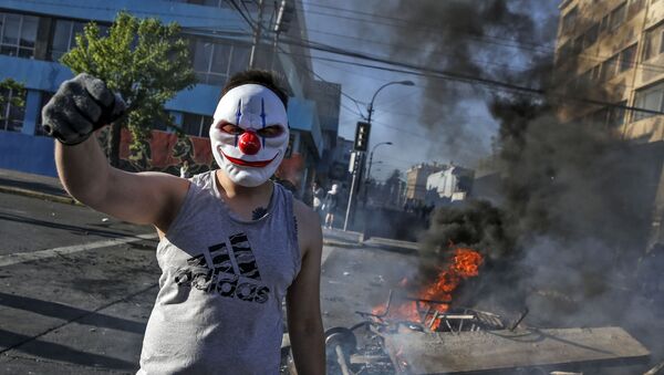 متظاهر ملثم أثناء تجدد الاحتجاجات في سانتياغو بعد مقتل اثنين من المتظاهرين، تشيلي 20 أكتوبر 2019 - سبوتنيك عربي