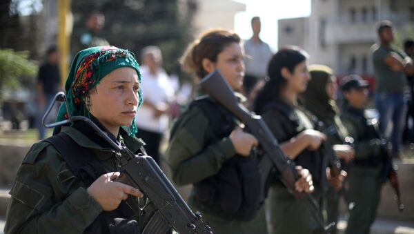 نساء من الشرطة الكردية يقفن أثناء مشاركة متظاهرين أكراد وعرب في مسيرة ضد الرئيس التركي والسير إلى مقر الأمم المتحدة في مدينة القامشلي - سبوتنيك عربي