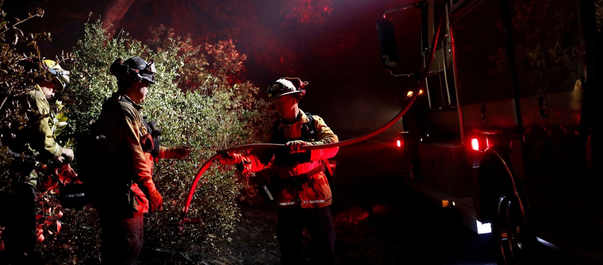 رجل إطفاء يمرر خرطوما لإخماد بقعة ساخنة أثناء حريق كينكايد في هيلدسبورغ، كاليفورنيا، الولايات المتحدة، 29 أكتوبر/تشرين الأول 2019 - سبوتنيك عربي, 1920, 27.02.2021