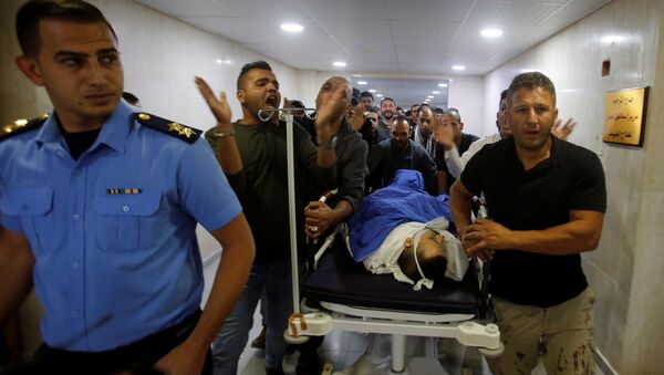 أشخاص ينقلون جثة الفلسطيني عمر البدوي في مستشفى في الخليل بالضفة الغربية التي تحتلها إسرائيل - سبوتنيك عربي