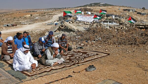 فلسطينيون يصلون الجمعة أثناء مظاهرة ضد المستوطنات اليهودية بالقرب من يطا في الضفة الغربية التي تحتلها إسرائيل - سبوتنيك عربي