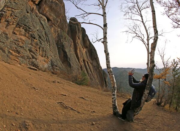 فتاة تلتقط صوراً صخور المرتفعات في منتزه المحمية الطبيعية ستولبي في إقليم كراسنويارسك الروسية - سبوتنيك عربي