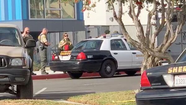 رجال الشرطة يقفون خارج مدرسة سوجس الثانوية بعد إطلاق نار، في سانتا كلاريتا، كاليفورنيا، الولايات المتحدة، 14 نوفمبر/تشرين الثاني 2019 - سبوتنيك عربي