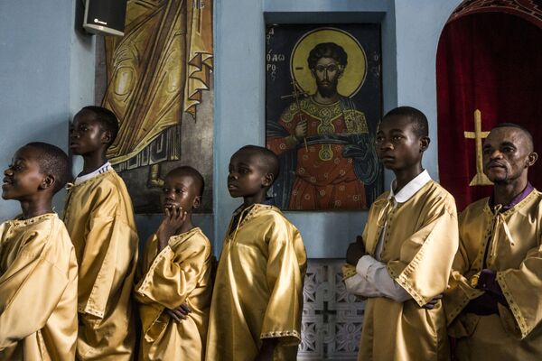 مساعدو الكاهن الكونغوليون للكنيسة الأرثوذكسية اليونانية يحضرون قداس الأحد في كاتدرائية القديس أندريو في كانانغا في 10 نوفمبر 2019 - سبوتنيك عربي