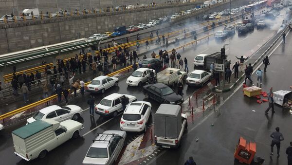 الناس يوقفون سياراتهم في طريق سريع لإظهار احتجاجهم على ارتفاع سعر الغاز في طهران - سبوتنيك عربي