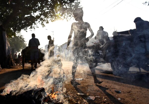 الناس يسيرون بجوار قمامة مشتعلة في كالكوتا، الهند 19 نوفمبر 2019 - سبوتنيك عربي