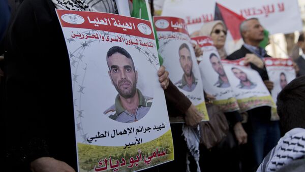 المتظاهرون يرفعون الأعلام الفلسطينية ويحملون صورًا لصور الأسير الفلسطيني في السجن الإسرائيلي سامي أبو دياك الذي توفي بالسجن - سبوتنيك عربي