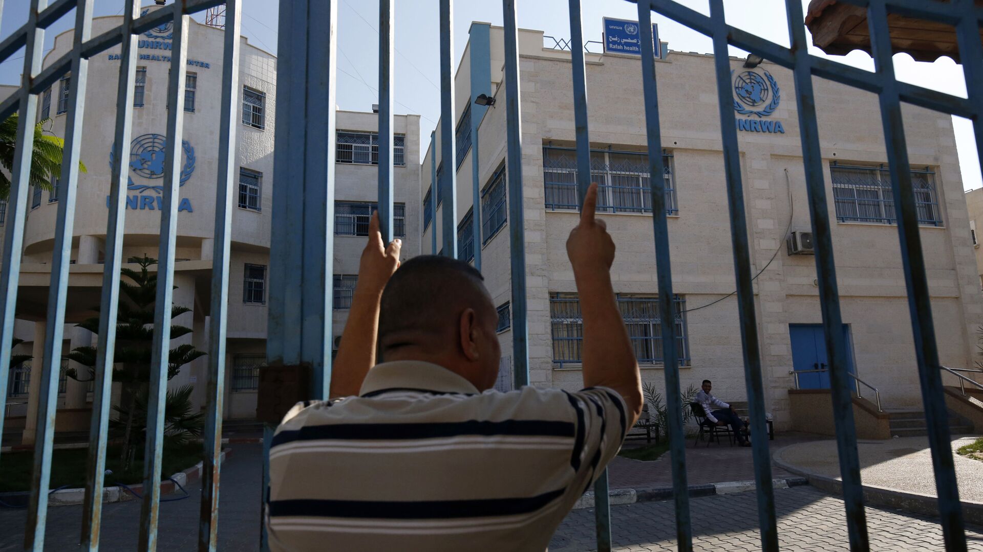 رجل فلسطيني يقف خارج البوابة المغلقة لوكالة غوث وتشغيل اللاجئين الفلسطينيين (الأونروا) - سبوتنيك عربي, 1920, 22.11.2022