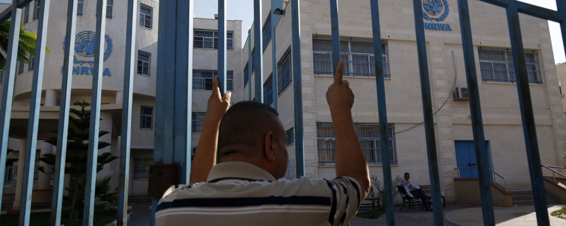 رجل فلسطيني يقف خارج البوابة المغلقة لوكالة غوث وتشغيل اللاجئين الفلسطينيين (الأونروا) - سبوتنيك عربي, 1920, 12.11.2021