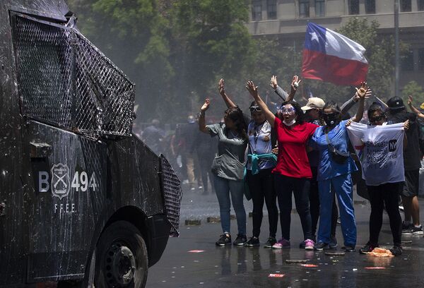 المشاركون في احتجاجت سانتياغو المناهضة للحكومة أما مقر البرلمان الرئاسي لا مونيدا، تشيلي 26 نوفمبر 2019 - سبوتنيك عربي