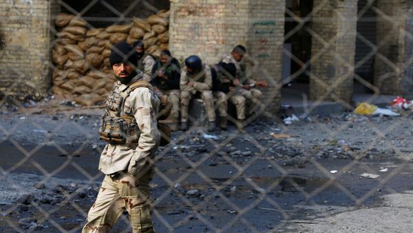 أحد أفراد قوات الأمن العراقية وراء السياج خلال الاحتجاجات المستمرة المناهضة للحكومة في بغداد - سبوتنيك عربي