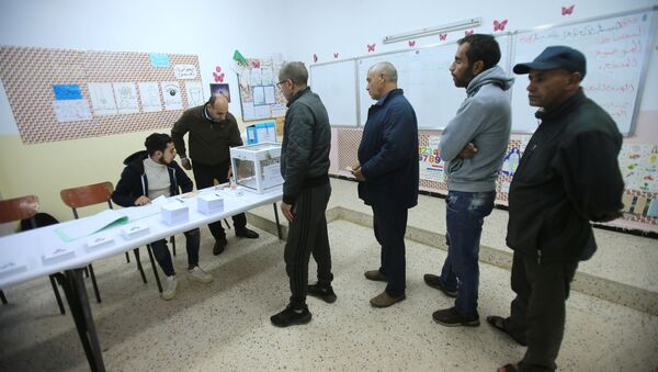 ينتظر الناخبون استلام بطاقات الاقتراع في مركز الاقتراع خلال الانتخابات الرئاسية في الجزائر العاصمة - سبوتنيك عربي