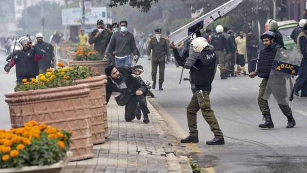 شرطي يهاجم محاميًا بعد اشتباكات بين محامين وأطباء في لاهور، باكستان 11 ديسمبر 2019 - سبوتنيك عربي