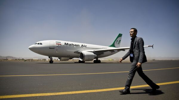 مسؤول أمن بمطار صنعاء اليمني يمشي على مدرج المطار بجوار طائرة تابعة لشركة الطيران الإيرانية الخاصة ماهان إير - سبوتنيك عربي