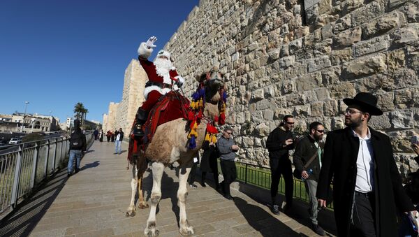 بابا نويل يمتطي جملا ويوزع أشجار عيد الميلاد في القدس - سبوتنيك عربي