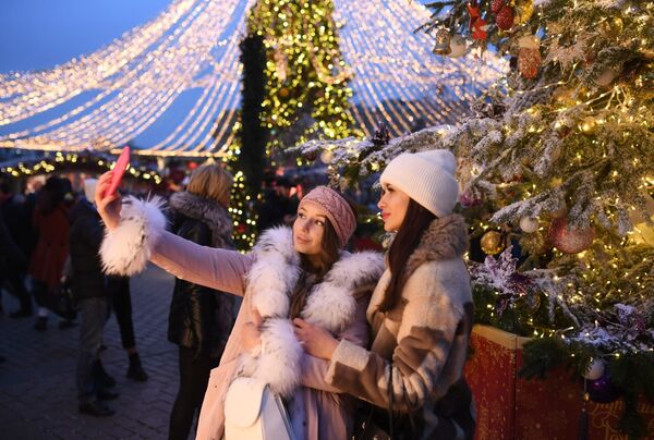 فتيات يلتقطن صور سيلفي على خلفية زينة مهرجان رحلة إلى عيد الميلاد على ساحة مانيجنايا وسط العاصمة موسكو، روسيا 13 ديسمبر 2019 - سبوتنيك عربي