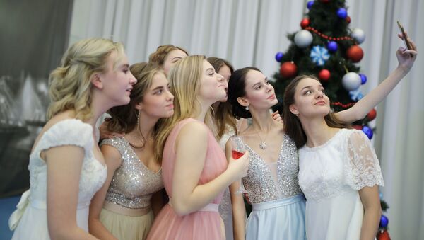 فتيات يلتقطن صورة سيلفي خلال حفل أقيم بمناسبة رأس السنة في معهد كراسنودار الرئاسي العسكري في كراسنودار الروسية، 14 ديسمبر 2019 - سبوتنيك عربي
