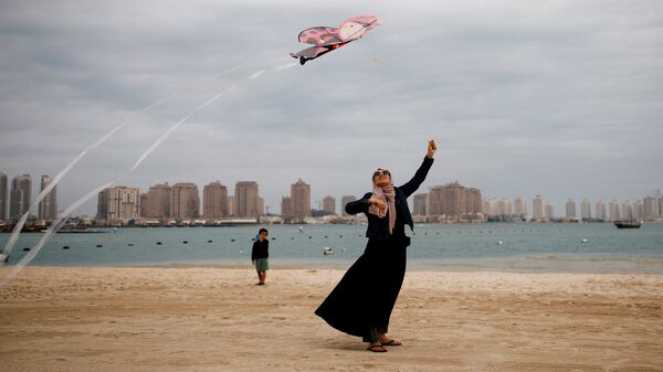 امرأة تطلق طيقا ورقيا على شاطئ كتارا في الدوحة، قطر 13 ديسمبر 2019 - سبوتنيك عربي