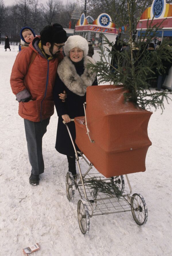 عائلة تعود إلى المنزل بعد شراء شجرة الميلاد من السوق، عام 1987 - سبوتنيك عربي