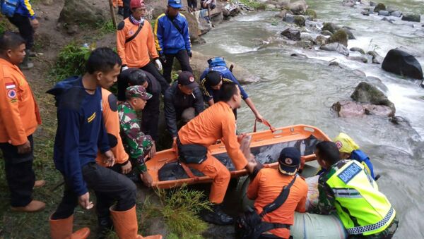 عمال الإنقاذ يحملون جثة ركاب حافلة سقطت جنوب سومطرة في إندونيسيا - سبوتنيك عربي