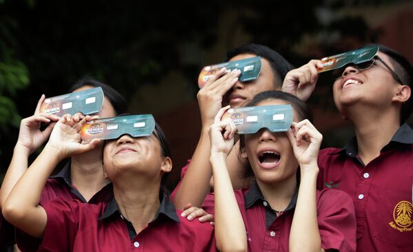 تلاميذ يشاهدون كسوف الشمس عبر نظارات خاصة في مدرسة سانتيراويذايالي في بانكوك، تايلاند 26 ديسمبر 2019 - سبوتنيك عربي