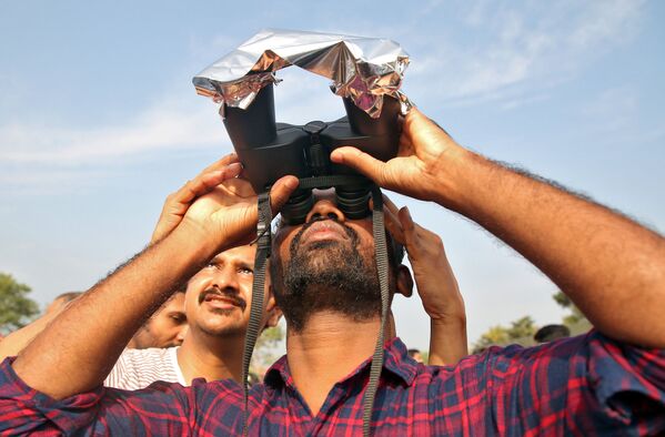 رجل يشاهد كسوف الشمس الحلقي في بلدة شيروفاتور في جنوب ولاية كيرالا، الهند 26 ديسمبر 2019 - سبوتنيك عربي