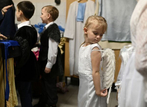 أطفال يستعدون لفعالية احتفالية بمناسبة عيد الميلاد في كنيسة كاثوليكية في أومسك، روسيا 24 ديسمبر 2019 - سبوتنيك عربي