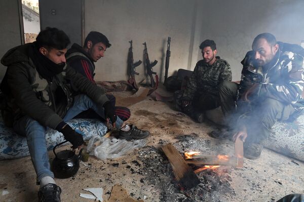 عناصر الدفاع الوطني خلال استراحة بعد تحرير بلدة من البلدات في محافظة إدلب، سوريا 23 ديسمبر 2019 - سبوتنيك عربي