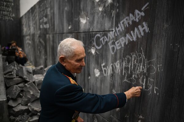 أحد رعاة الحرب العالمية الثانية المخضرم روستيسلاف دميترييفيتش بيتيانوف، يكتب على جدار الرايخستاغ في متحف التاريخ معركة من أجل برلين، برلين، ألمانيا 5 نوفمبر 2019 - سبوتنيك عربي