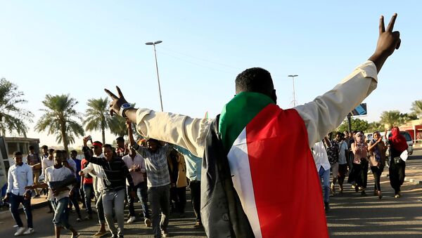 متظاهر سوداني يحتفل بالذكرى الأولى لثورة السودان - سبوتنيك عربي