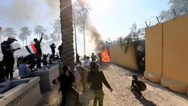 متظاهرون يحرقون سور السفارة الأمريكية في العراق - سبوتنيك عربي