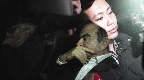 رئيس نيسان السابق كارلوس غصن مع محاميه تاكاشي تاكانو في سيارة في طوكيو بعد إطلاق سراح غصن وتنعكس صورة طاقم تلفزيوني على نافذة السيارة - سبوتنيك عربي