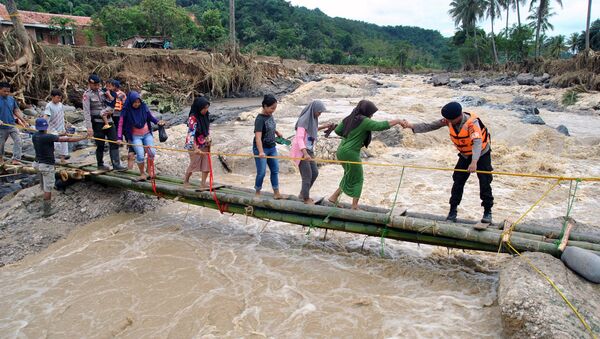 الشرطة تساعد سكان مدينة بوكور في إندونيسيا بعبور جسر الطوارئ - سبوتنيك عربي